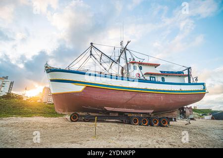 October 25, 2024, this photograph showcases a boat anchored in the sand of Navegantes, SC, Brazil, during a serene late afternoon. The soft glow of th Stock Photo