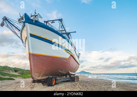 October 25, 2024, this photograph showcases a boat anchored in the sand of Navegantes, SC, Brazil, during a serene late afternoon. The soft glow of th Stock Photo