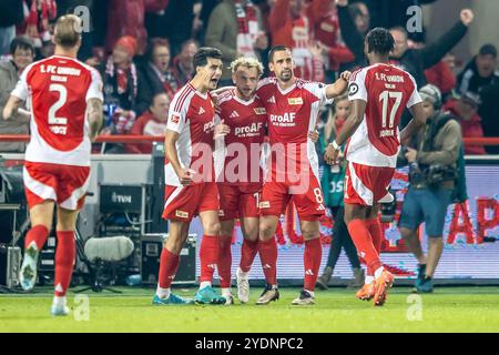 Berlin, Germany. 27th Oct, 2024. Soccer: Bundesliga, 1. FC Union Berlin - Eintracht Frankfurt, Matchday 8, An der Alten Försterei. Berlin's Benedict Hollerbach (3rd from right) scores to make it 1:1 and celebrates with his teammates. Credit: Andreas Gora/dpa - IMPORTANT NOTE: In accordance with the regulations of the DFL German Football League and the DFB German Football Association, it is prohibited to utilize or have utilized photographs taken in the stadium and/or of the match in the form of sequential images and/or video-like photo series./dpa/Alamy Live News Stock Photo