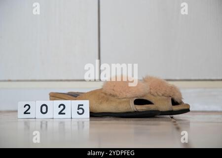 2025 written on white wooden cubes next to women's slippers in an apartment in Ukraine Stock Photo