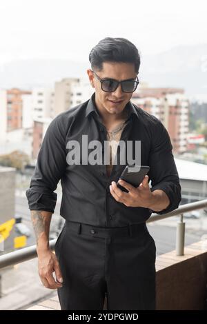 Using cell phone a young latino man with short hair, communication and globalization, lifestyle Stock Photo