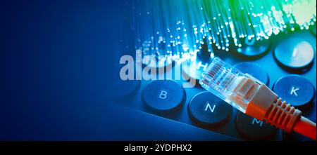 Ethernet cable on computer keyboard. Fast internet concept with optical fiber Stock Photo