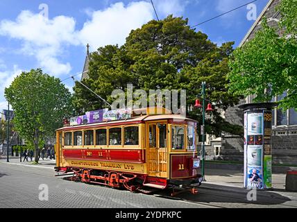 Christchurch, New Zealand - October 30, 2023; Historic Tram outside The Christchurch Arts Centre Clock Tower and Ernest Rutherford Rooms, New Zealand Stock Photo