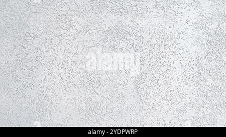 A white wall with a rough texture. The wall is covered in small white dots. The wall appears to be unfinished and unfinished Stock Photo