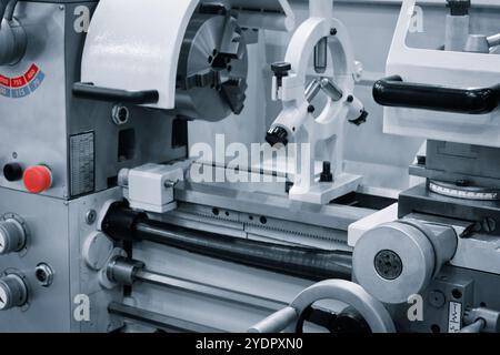 A machine with a red button on the front. The machine is a lathe. The red button is a safety feature Stock Photo