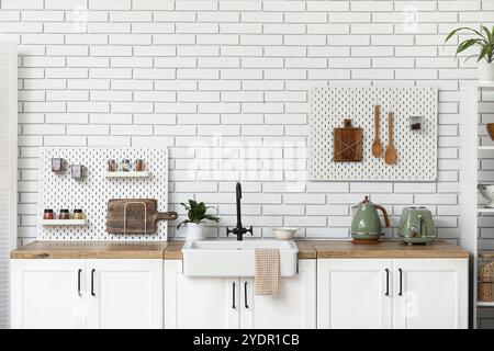 Stylish light kitchen with pegboards and kitchenware Stock Photo