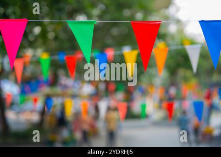 Decorative multi-colored triangle flags against the background at the festival in Thailand. Stock Photo