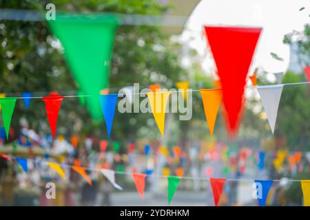 Decorative multi-colored triangle flags against the background at the festival in Thailand. Stock Photo