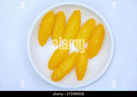 Close-up of med kanoon in serving dish, a Thai dessert made of sweet beans paste dipped in beaten eggs, then cooked in syrup, isolated on white Stock Photo