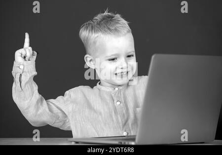 Amazed child using gadgets to study. Computer education for kids. Genius child programming, computer training. Stock Photo