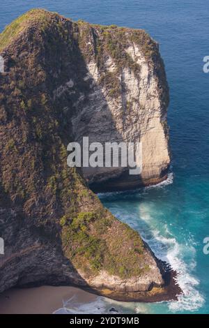 From above, turquoise waves gently crash onto the soft sands of Kelingking Beach in Nusa Penida, Bali. Stock Photo