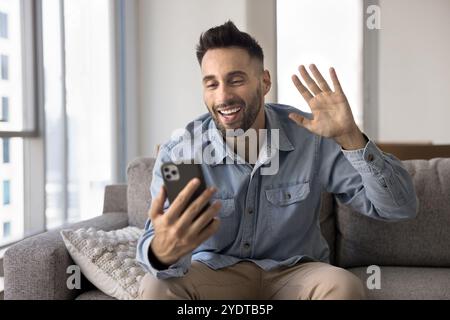 Cheerful man talking on online video conference chat on smartphone Stock Photo