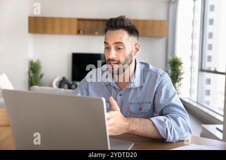 Handsome young Latin freelancer man speaking on online conference chat Stock Photo