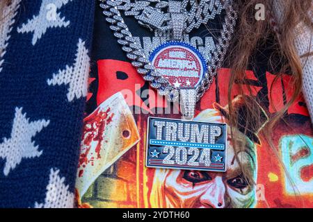 New York, United States. 27th Oct, 2024. A close up of Trump jewelry worn by a supporter. Former President Donald Trump held a rally for his supporters at New York's Madison Square Garden just 7 days before the elections. An estimated twenty thousand people waited inside the Garden for Trump to speak while those that could not get in gathered outside along with those protesting Trump. Credit: SOPA Images Limited/Alamy Live News Stock Photo