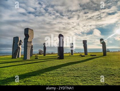 Dodekalitten Large stone sculptures stand majestically on a grassy field by the coast, under a vibrant sky. This serene setting evokes mystery and con Stock Photo