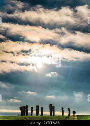 Dodekalitten Large stone sculptures stand majestically on a grassy field by the coast, under a vibrant sky. This serene setting evokes mystery and con Stock Photo