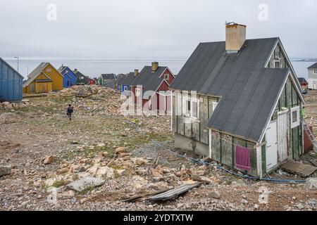 Colourful houses on rocky terrain near the coast, fjord, remote Arctic Inuit settlement Ittoqqortoormiit, Scoresbysund or Scoresby Sund or Greenlandic Stock Photo