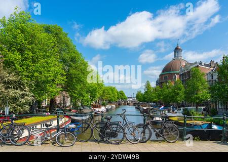 Bikes on Corsgenbrug bridge over Singel canal and Renaissance dome of Koepelkerk Church in the background, Amsterdam, The Netherlands, Europe Stock Photo