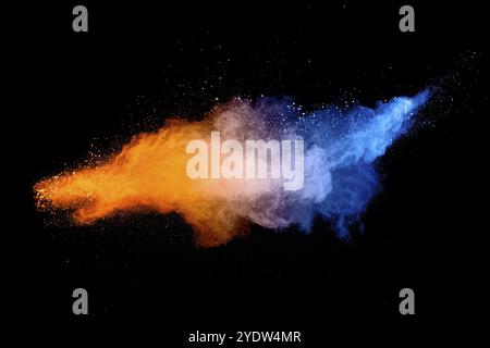 Blue orange color powder explosion cloud on black background. Closeup of Blue orange dust particles splash Stock Photo
