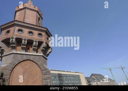 Historic brick tower in an urban setting with modern buildings and a crane against a blue sky, Berlin, Germany, Europe Stock Photo