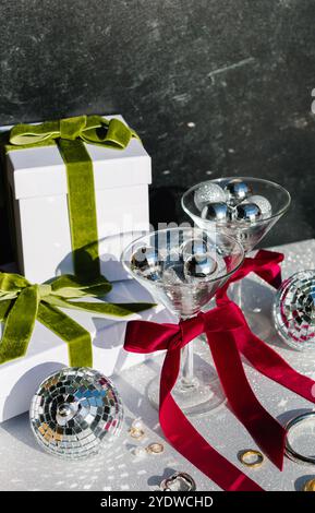 Gift boxes with velvet ribbons, martini glasses, and disco balls Stock Photo