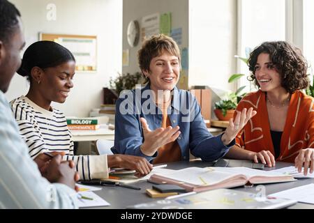 Smiling Teacher Engaging Students in Study Session Stock Photo