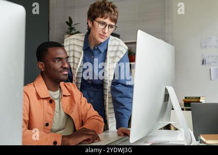 Collaborating on Computer Project in Office Environment Stock Photo