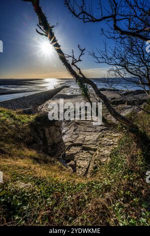 Shining waters as the sun reflects on the Jack Scout area of coast at Silverdale on Morecambe Bay. Seen at the point where the river Kent flows into t Stock Photo