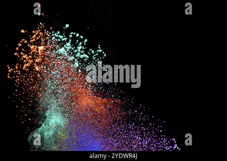 Multicolored powder explosion on black background.Launched colorful powder on black background.Color powder explosion.Colorful dust splashing Stock Photo