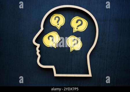 Head with question marks inside symbolizing uncertainty or curiosity. Stock Photo