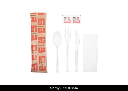 Disposable plastic cutlery set with fork, spoon, knife in transparent packaging with napkin and seasoning packets on white background, restaurant supp Stock Photo