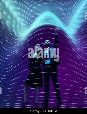 Business man and woman in professional attire analyze complex data visualized as flowing digital waves on vibrant gradient background. Collage. Stock Photo