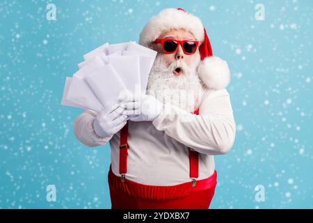 Portrait of his he nice attractive amazed wondered overwhelmed thick white-haired Santa holding in hand many mail gift wish list lottery isolated Stock Photo