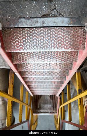Example of chemical plant steampunk retro style interior part with copyspace. Abstract image of industrial textured rusted stairs going down vertical Stock Photo