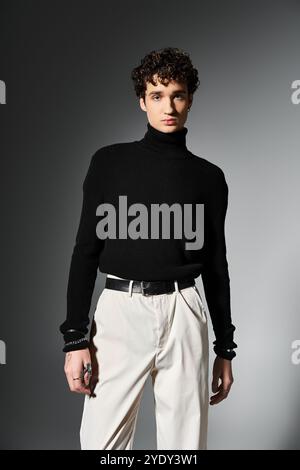 A handsome young man showcases his charismatic style in a black turtleneck, exuding confidence on a dark background. Stock Photo