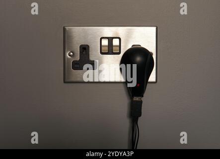 UK wall electric plug socket (brushed silver) with switch and 5V power adapter Stock Photo