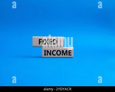 Fixed Income symbol. Concept word Fixed Income on wooden blocks. Beautiful blue background. Business and Fixed Income concept. Copy space Stock Photo