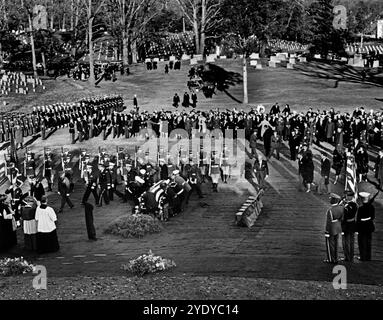 Kennedy family members: U.S. Attorney General Robert F. Kennedy, Jacqueline Kennedy, U.S. Senator Edward M. Kennedy, Rose Fitzgerald Kennedy, Steven Smith, Peter Lawford, Jean Kennedy Smith, Eunice Kennedy Shriver, follow as Honor guard pallbearers place the flag-draped casket of U.S. President John F. Kennedy at gravesite, during graveside services in the state funeral of President Kennedy, Arlington National Cemetery, Arlington, Virginia, USA, Abbie Rowe, White House Photographs, November 25, 1963 Stock Photo