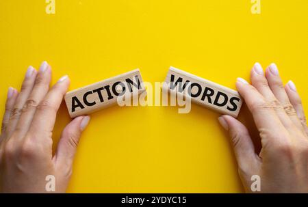 Action or words symbol. Concept word Action or words on wooden blocks. Businessman hand. Beautiful yellow background. Business and Action or words con Stock Photo