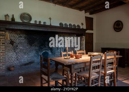 Big hearth / open fireplace and dining table in 18th century farmhouse Uitschoolhoeve Oevel at open air museum Bokrijk, Limburg, Flanders, Belgium Stock Photo