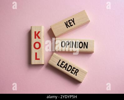 KOL - Key Opinion Leader symbol. Concept word KOL on wooden blocks. Beautiful pink background. Business and KOL concept. Copy space. Stock Photo