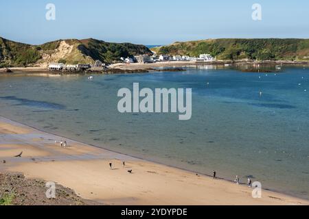 People relax on the beach at Porthdinllaen in Morfa Nefyn on the Llyn Peninsula in North Wales. Stock Photo