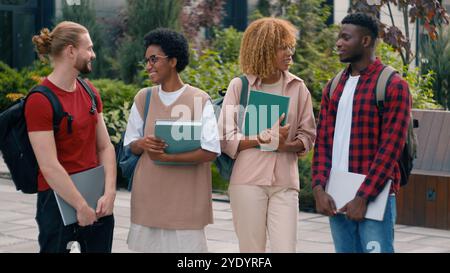 Diverse multiracial gen z friends happy smiling teens students pupils high school university college academy talking together laughing in city Stock Photo