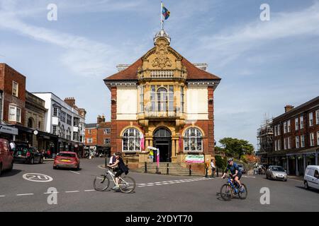 Cyclists ride past Marlborough Town Hall in Wiltshire, England. Stock Photo