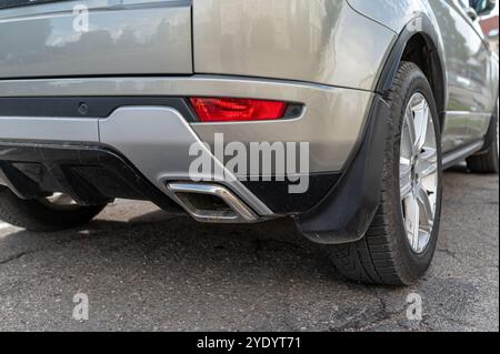 A silver SUV parked in a lot next to other vehicles under a bright afternoon sky. Stock Photo