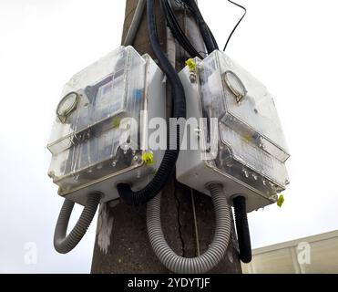 Voronezh, Russia - February 14, 2024: Placement of electric meters on a pole in transparent boxes Stock Photo