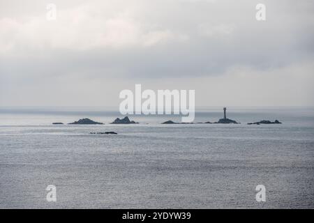 Sun shines on the Longships rocks and lighthouse off Land's End in the west of Cornwall, England. Stock Photo