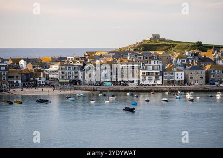 People gather along the quayside and beach of St Ives Harbour in Cornwall, England. Stock Photo
