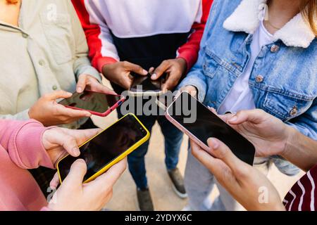 Closeup of teen group of friends using mobile phones Stock Photo