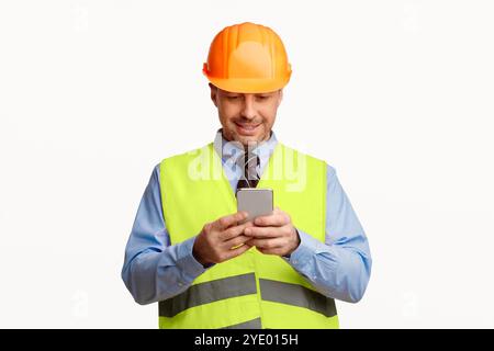 Construction Worker Using Smartphone Standing On White Studio Background Stock Photo